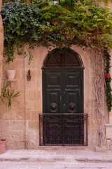 Old-fashioned maltese door on the narrow street in Valetta, Malta. Vintage authentic entrance to the building