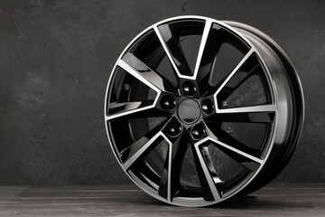black beautiful alloy wheel on a texturally dark background