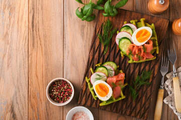 Fototapeta na wymiar Savory waffles. Breakfast green waffles wild garlic or spinach with egg, tomato, salmon on wooden plate for breakfast on old wooden background. Light dinner, lunch or breakfast. Top view. Mock up.