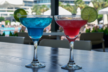 Cocktails on terrace. Red and blue cocktail on a wooden table in a cafe, on vacation