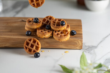 homemade belgian waffels with blueberry and honey on marble table. Vertical