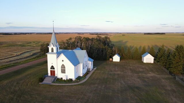 A newly renovated wooden church from the 20th century in the countryside of Alberta, Canada. Wide angle aerial parallax shot