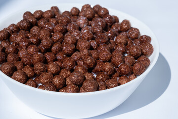 chocolate granules balls in milk in a white plate for breakfast

