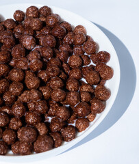 chocolate granules balls in milk in a white plate for breakfast
