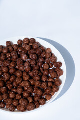 chocolate granules balls in milk in a white plate for breakfast
