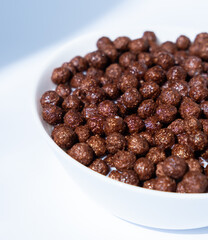 chocolate granules balls in milk in a white plate for breakfast
