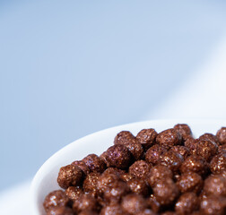 chocolate granules balls in milk in a white plate for breakfast
