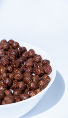 chocolate granules balls in milk in a white plate for breakfast
