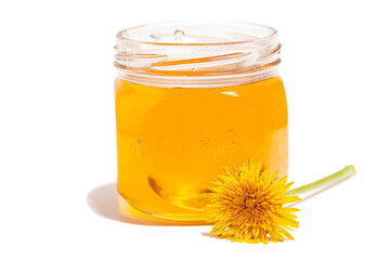 Honey dripping from honey dipper in glass jar with dandelion . Healthy food concept