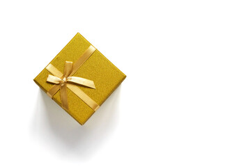 Golden gift box with bow isolated on a white background. Flat lay