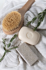 Dry brush pumice and soap bar on white spa towel