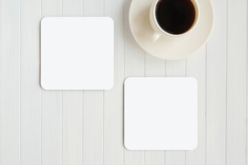Two square white blank coasters mockup for design or logo presentation, composition with cup of coffee on white table.