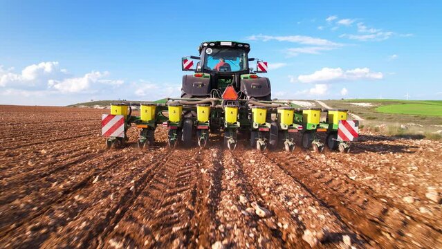 Agricultural tractor sowing and cultivating field. High quality 4k footage
