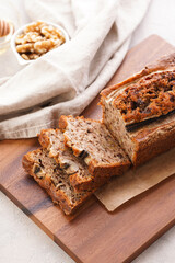 Chocolate banana bread with walnuts on a wooden board and ingredients on a grey neutral background