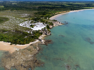 Amazing paradisiacal and deserted beach with clear blue waters and visible corals at low tide - Cumuruxatiba, Bahia, Brazil - aerial drone view