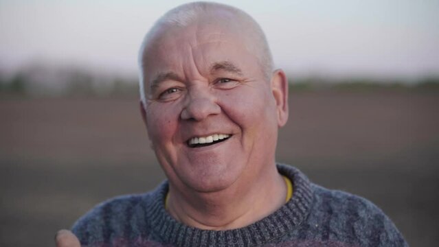 Portrait of a smiling senior adult man who looking into the camera. The pensioner enjoys life. Cheerful sincere emotion of elderly people. Wrinkled face of an old peasant.The concept of happy old age