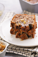 Slices of Chocolate banana bread with walnuts on a checkered kitchen napkin and ingredients on a grey neutral background