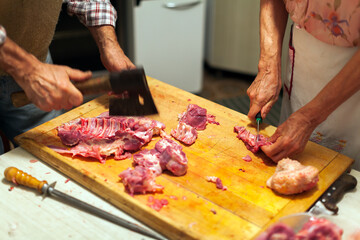 Senior Couple Cutting Whole Turkey in Domestic Kitchen Close up on Hands