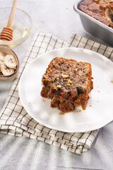 Slices of Chocolate banana bread with walnuts on a checkered kitchen napkin and ingredients on a grey neutral background with creative lighting