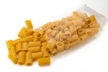 Paccheri pasta coming out of transparent bag isolated on white, typical Italian macaroni from Gragnano