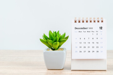 December 2022 desk calendar on wooden background.