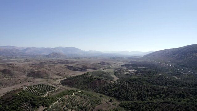 Video with drone advancing over the plain of the interior of Albania in Saranda, Dry, sunny weather and drought predominates in nature, Descriptive frontal plane video.