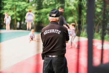 Rear view of security guard looks at the children's trampoline