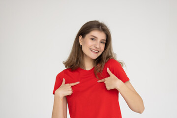 This is me. Portrait of happy young woman pointing herself isolated on gray background.