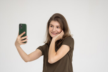 Fototapeta premium Portrait of a smiling woman making selfie photo on smartphone isolated on a white background