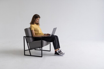 Beautiful and happy woman working with a laptop over white background