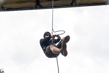  Rappelist man going up the walkway on the rappel rope. - obrazy, fototapety, plakaty
