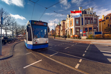 Amsterdam tram, dutch flag against background of typical Dutch houses, Holland, Netherlands.