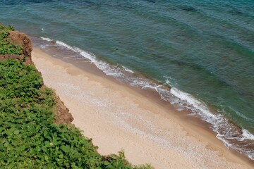 Beach on aerial drone top view with ocean waves reaching shore, top view photo of an amazingly beautiful sea landscape.