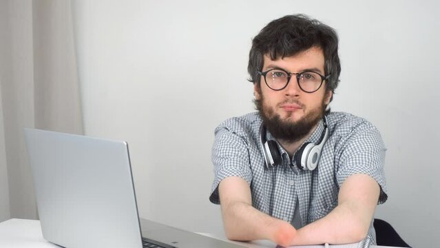 Disabled man with amputated two stump hands studying on laptop at home looking at camera, distance education. Problem of adaptation to life people with disabilities. Independent Invalid person.