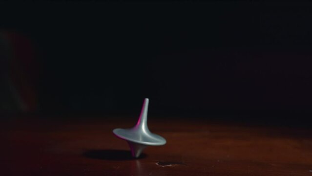 Top spinning on a wooden table in slow motion