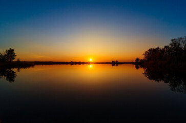 Beautiful sunset over the lake. Dust