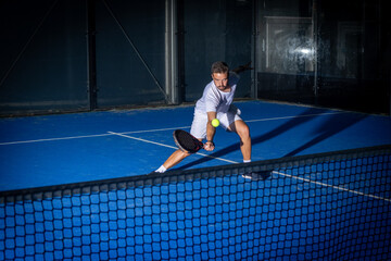 Man playing padel tennis indoor