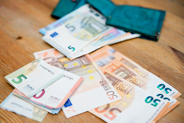Saving money. Keeping savings in wallet. Open purse with Euro banknotes out from it. Finance, savings, investing. Money management at home. Financial business concept