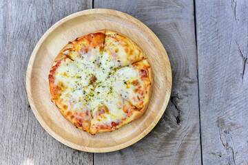 homemade pizza or Italian Pizza in chopping board on a wooden table. top view, copy space.