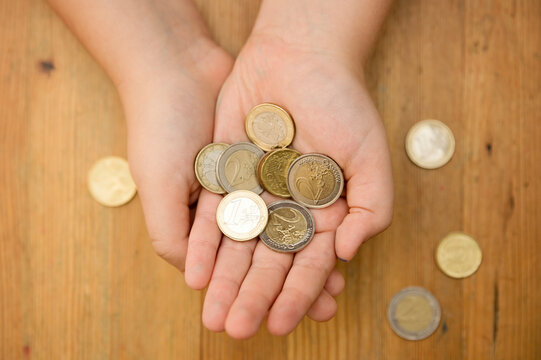 Euro coins in kids hands. Currency transfer, investment, payment, donation, gift concept. Saving money for the future, education, car, weddings.