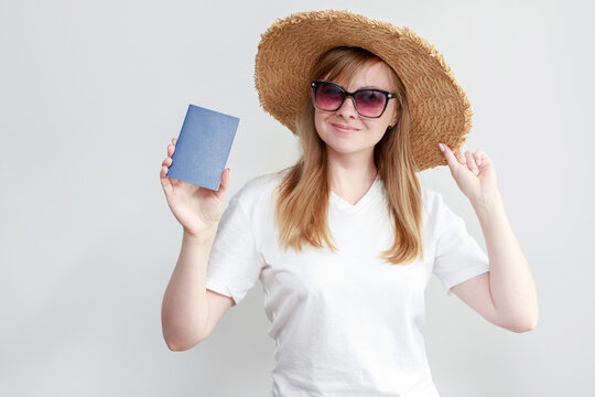 a woman in a hat and glasses with a passport on a white background