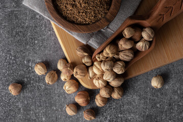 White cardamom in a wooden spoon and bowl. Dry cardamom spice. Cardamom seeds macro shot.