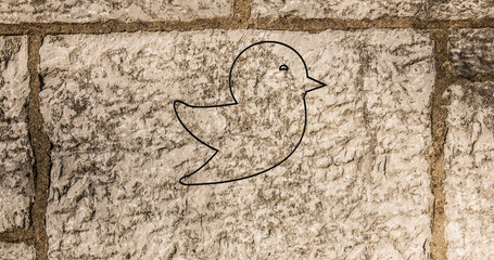 Image of glowing neon bird icon on brick wall