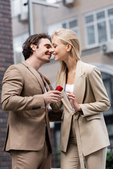 smiling man making marriage proposal to stylish blonde woman on urban street.