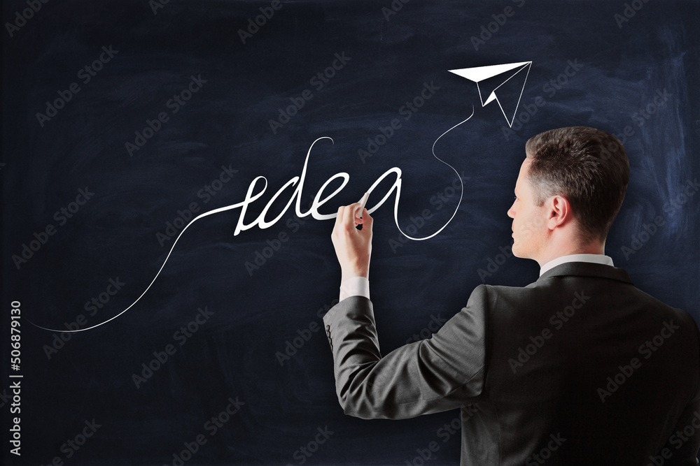 Poster idea, creativity and strategy concept with man in black suit writing by chalk idea word with paper p