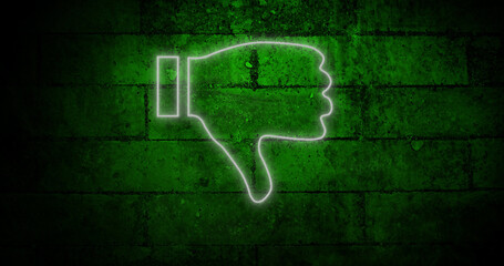 Image of glowing neon thumb down icon on brick wall