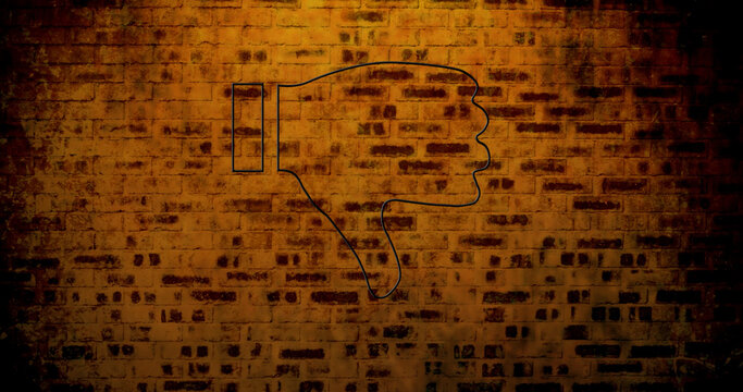 Image of glowing neon thumb down icon on brick wall