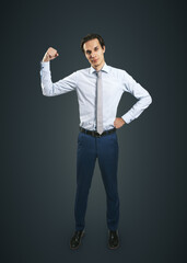Buiness leader concept with young man in white shirt raising his hand to show his power on dark grey background