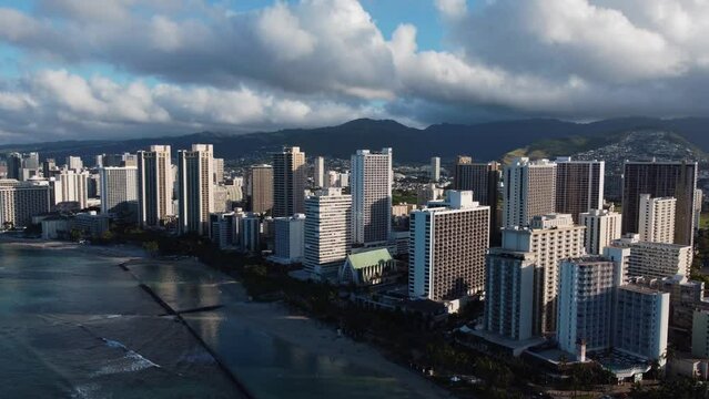 4K cinematic clockwise drone shot of Waikiki Beach and the hotels behind it during sunrise in Oahu. This famous Hawaiian scene was filmed using a DJI Mini 2 drone.