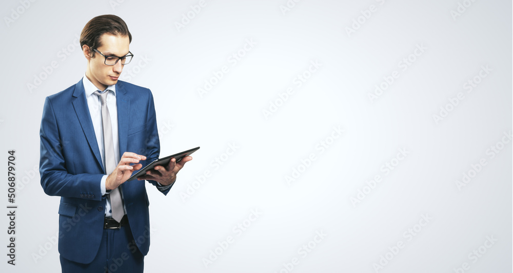 Poster young businessman in suit with digital tablet on white background with place for your text, mock up